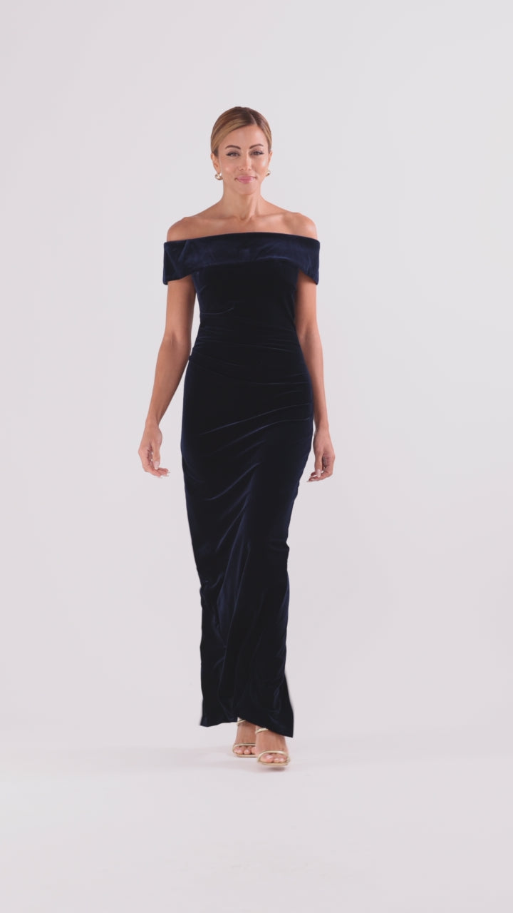 Navy “Lori” Velvet Off The Shoulder Ruched Dress, shown while walking with skirt movement